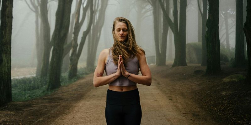 Woman Meditating on Forest Road