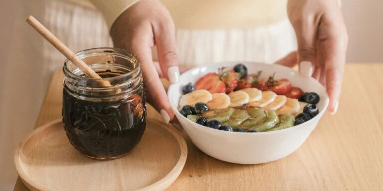 Recipe Ideas - Person Preparing a Bowl of Sliced Fruits with Syrup