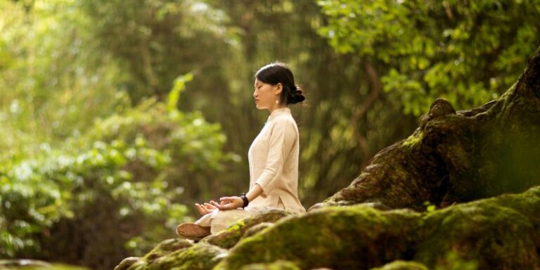 Woman Meditating on a Tree Trunk