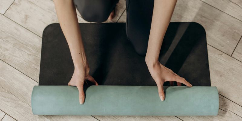 30-Day Yoga - Woman in Black Leggings Unrolling A Yoga Mat