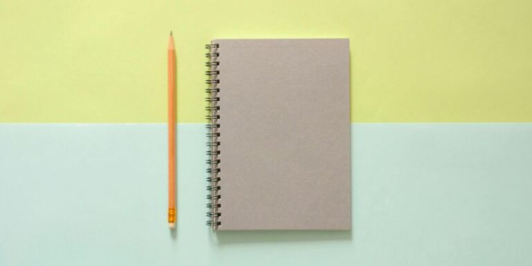 Design the Life You Want - White Spiral Notebook Beside Orange Pencil