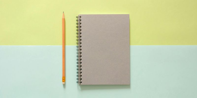 Design the Life You Want - White Spiral Notebook Beside Orange Pencil