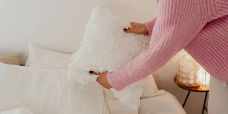 Night Routine - Woman in Pink Knit Sweater Holding a White Pillow
