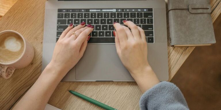 Improve Your Day - Person Using Macbook Pro on Brown Wooden Table