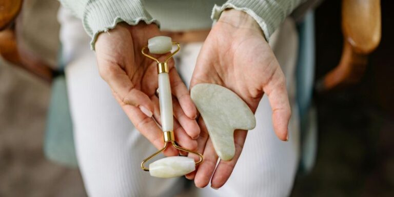 A Close-Up Shot of a Person Holding a Face Roller and a Gua Sha