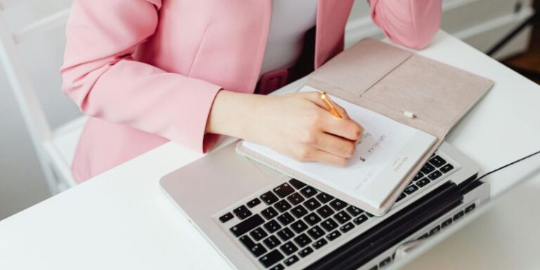 Personal Development - Woman in Pink Blazer Writing on Notepad