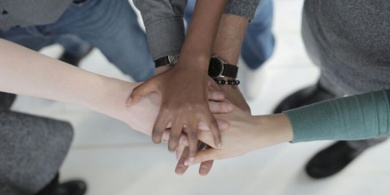 affirmations for success - Crop unrecognizable multiethnic colleagues joining hands