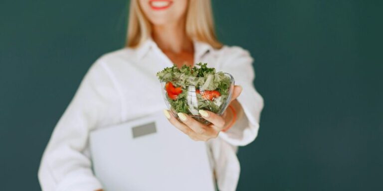 improve your health - Woman Holding a Bowl with Salad and Smiling